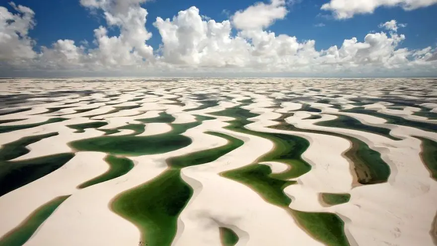 19 Jul 2009, Brazil --- Lençois Maranhenses National Park is a coastal dune field (measuring some 155,000 hectares) that is flooded with fresh water lakes during the January to May rainy season. Strong prevailing winds from the East mobilize the barchan dunes during the dry season and, combined with the equatorial sun, evaporate the lakes and prevent permanent vegetation from taking root. The dunes are composed of quartz grains that are eroded from the granite and washed down from the Parnaiba River and then carrie --- Image by © George Steinmetz/Corbis