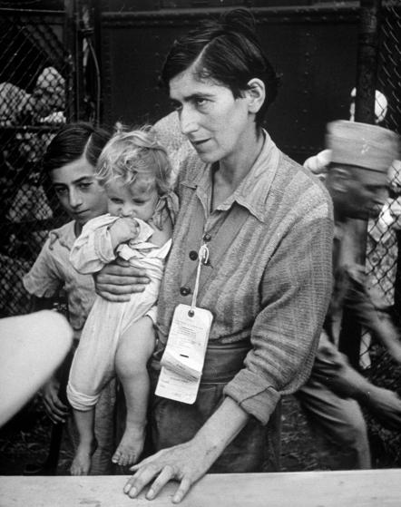 Swiss Jew Eva Bass, formerly a nightclub singer in Paris, entering refugee camp at Fort Ontario, with her children Yolanda and Joachim, whom she carried on a sixty-kilometer trek through the fighting lines to reach American transport ship Henry Gibbins.